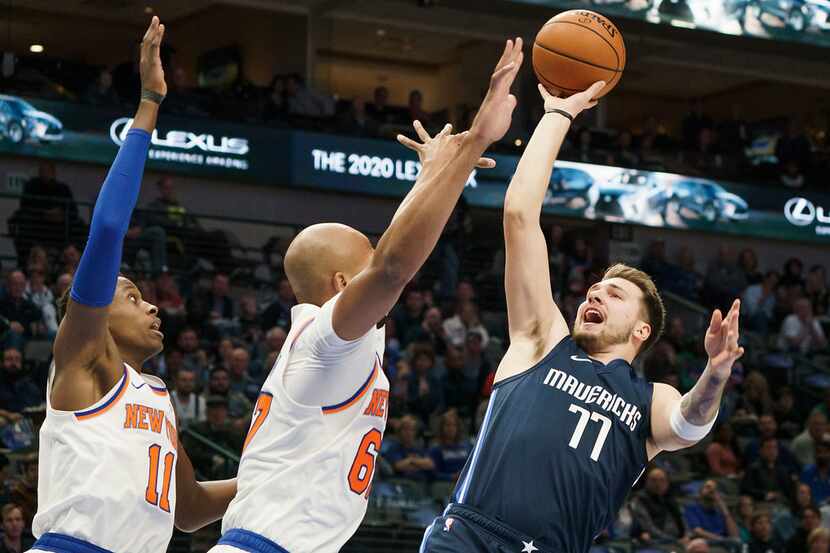 Dallas Mavericks guard Luka Doncic (77) puts up a shot over New York Knicks forward Taj...