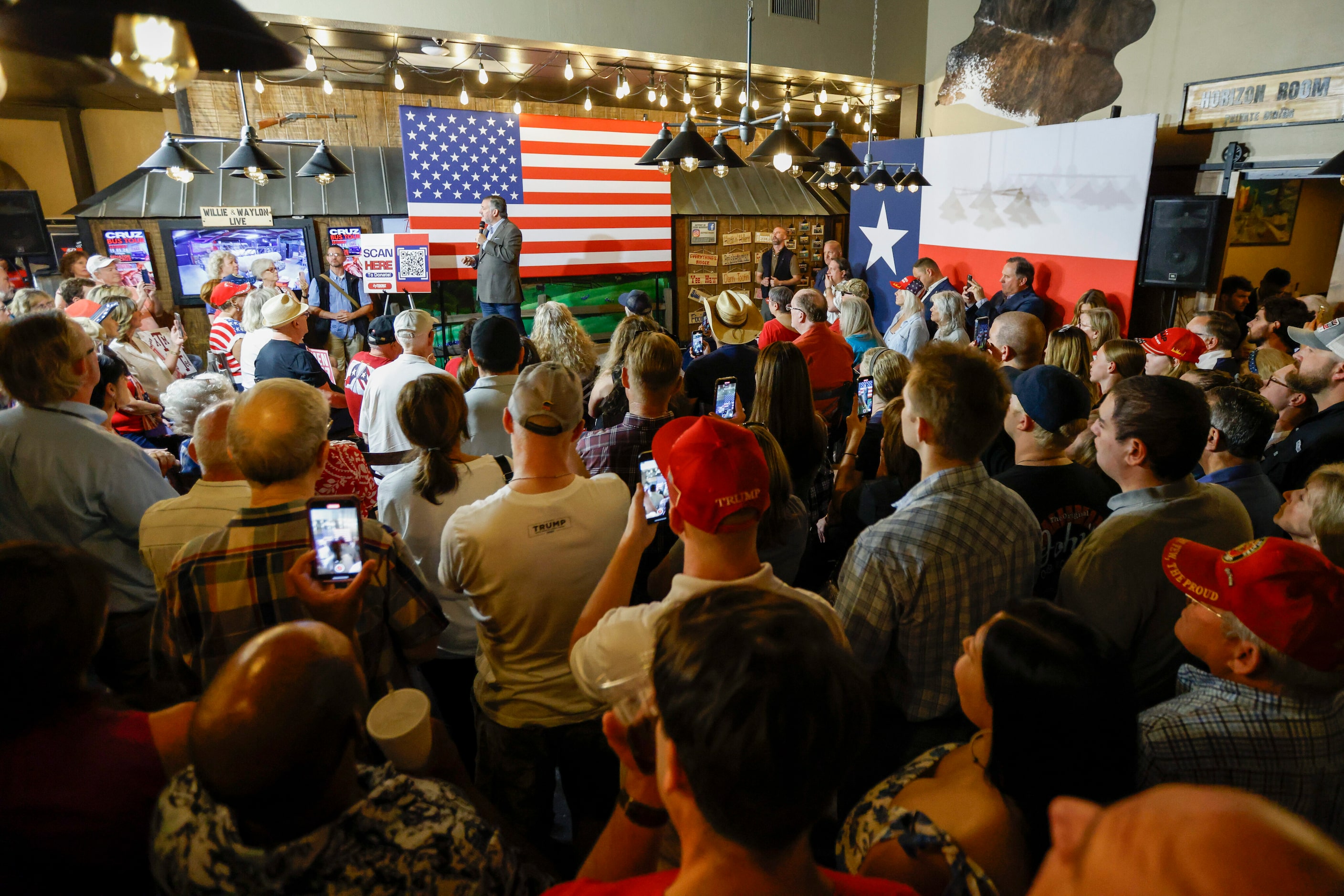 Dozens of people gather to watch Senator Ted Cruz (R-Texas) during a campaign rally at...