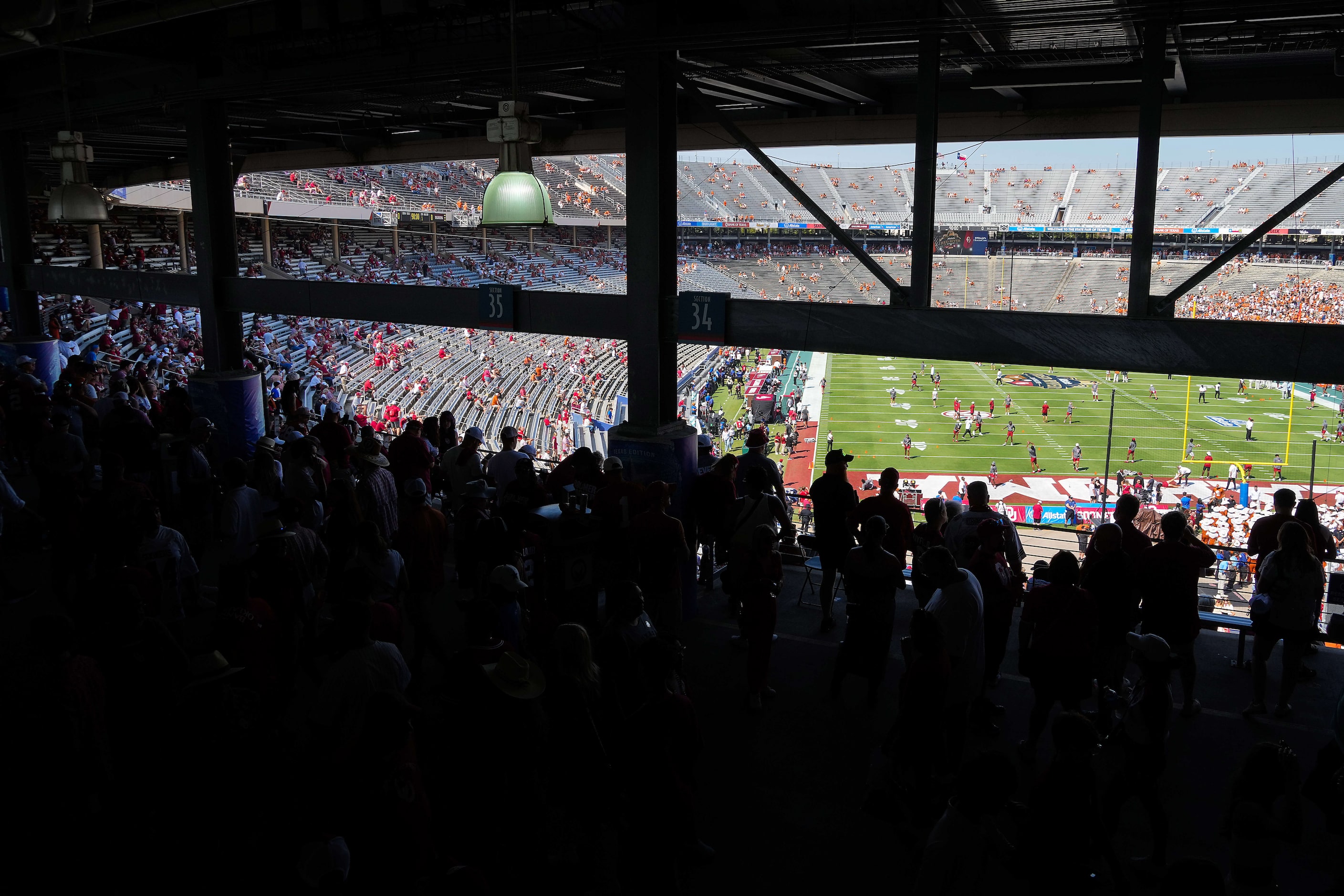 Fans watch the teams warm up from concourse before an NCAA college football game between...