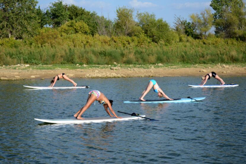 Local residents do paddleboard yoga on Lake Lewisville. Paddleboard yoga came to Lewisville...