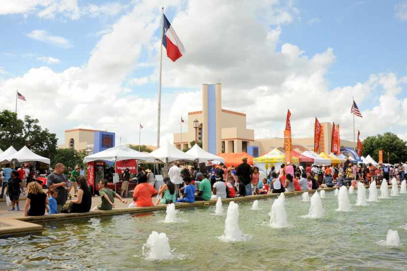 Festival goers sit by the fountain and enjoy food at Taste of Dallas in Fair Park .