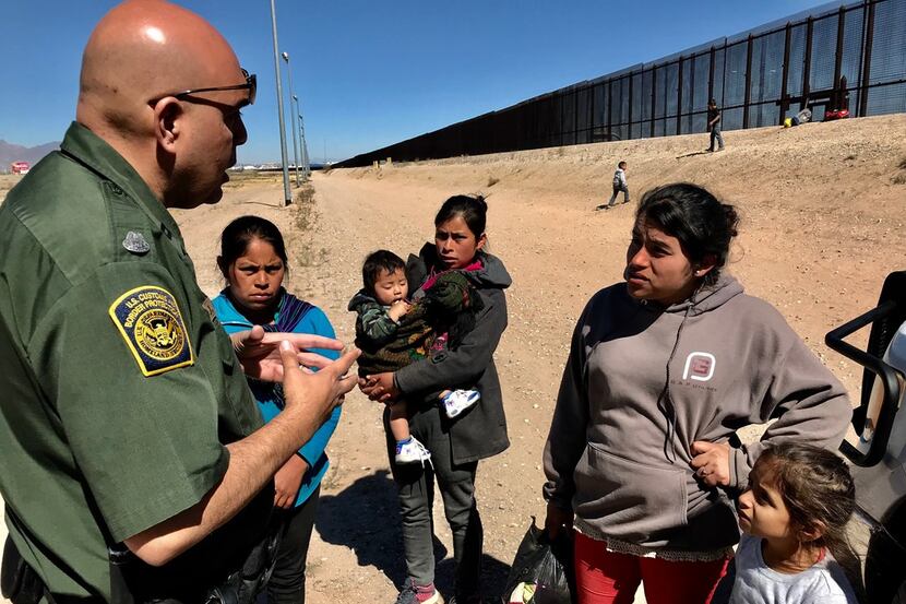 Migrants who crossed the border and turned themselves in to the border patrol were being...
