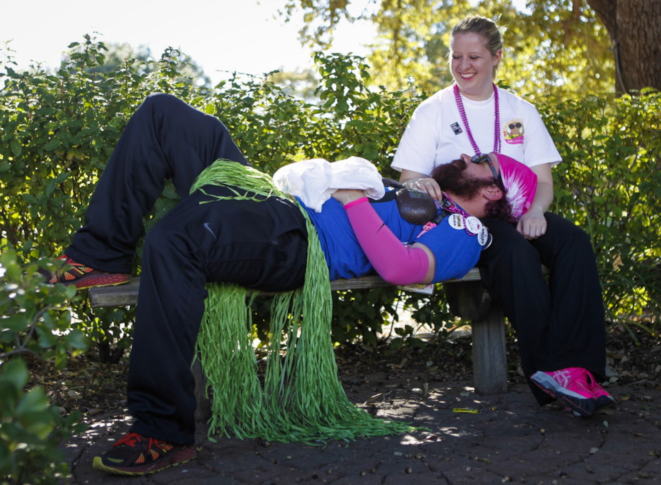 Anthony Childress of Dallas rests in Nikki Fullen's lap after finishing the 2014 Susan G....