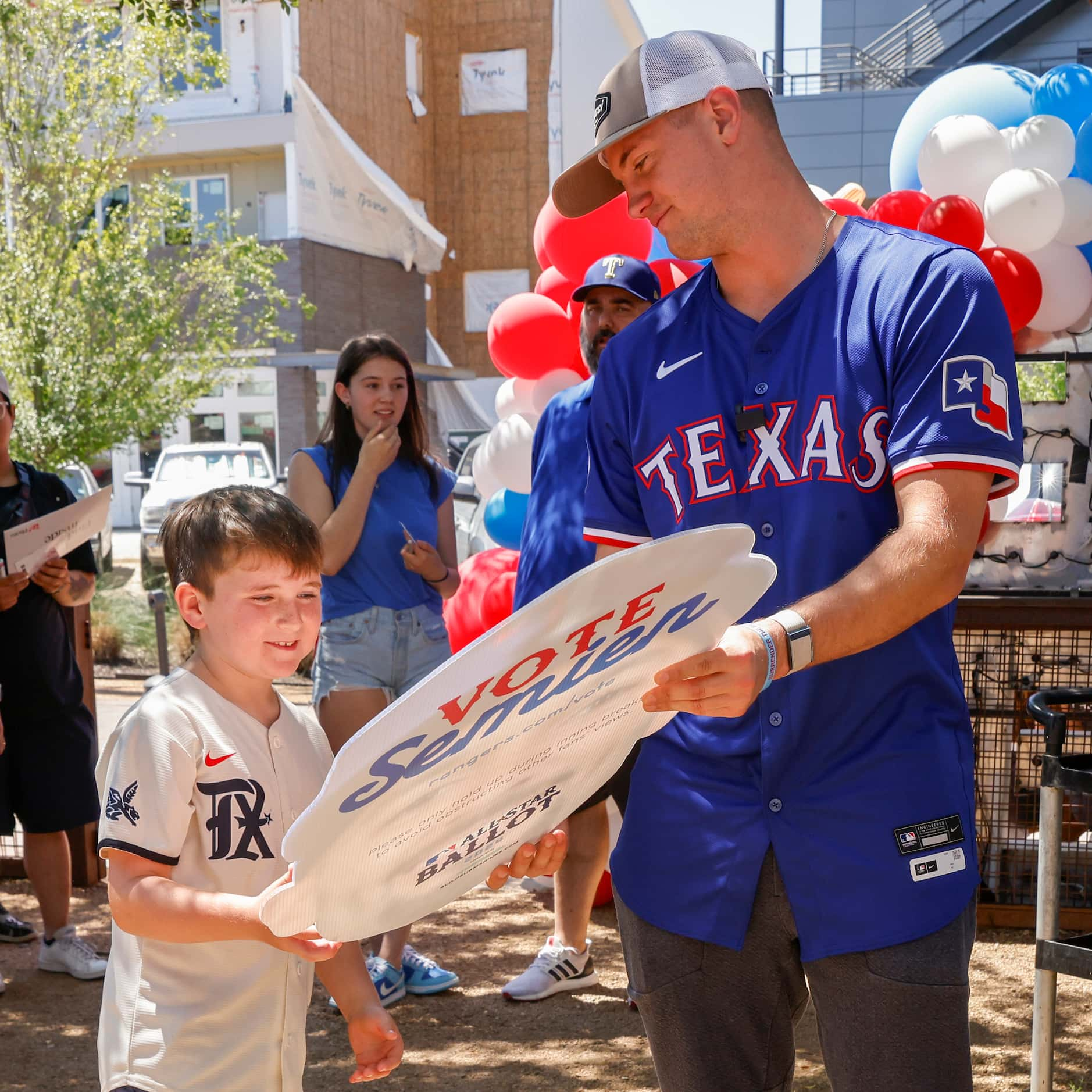 Texas Rangers third baseman Josh Jung gives a cutout of Marcus Semien to Bennett Hurtado, 7,...