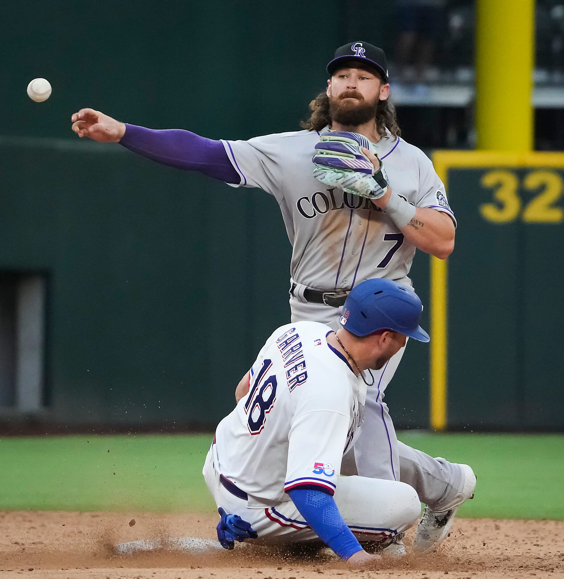 Texas Rangers catcher Mitch Garver (18) slides into Colorado Rockies second baseman Brendan...