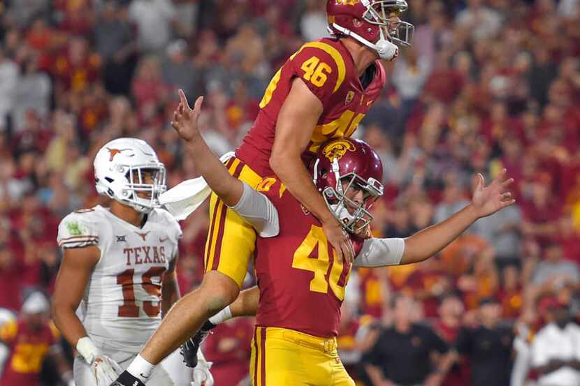 Southern California's Chase McGrath, lower right, celebrates with Wyatt Schmidt as Texas...