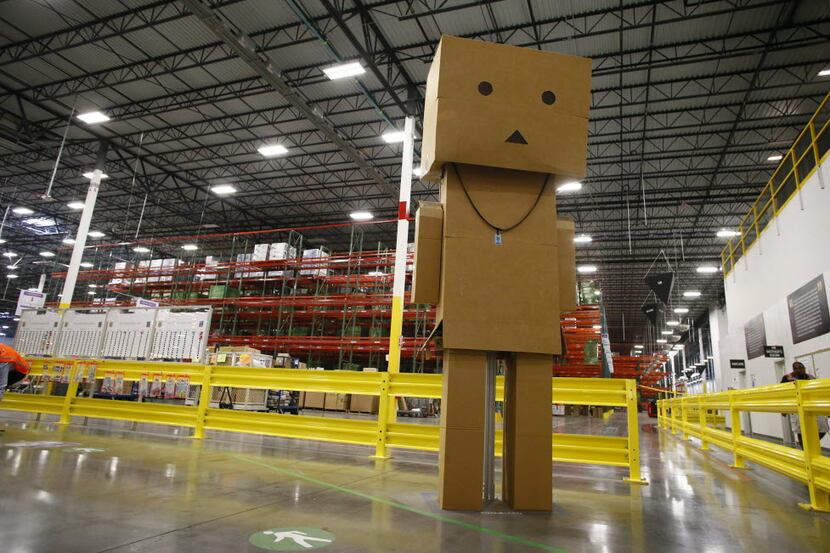 A giant box man stands at the entrance of the Amazon.com fulfillment center in Coppell,...