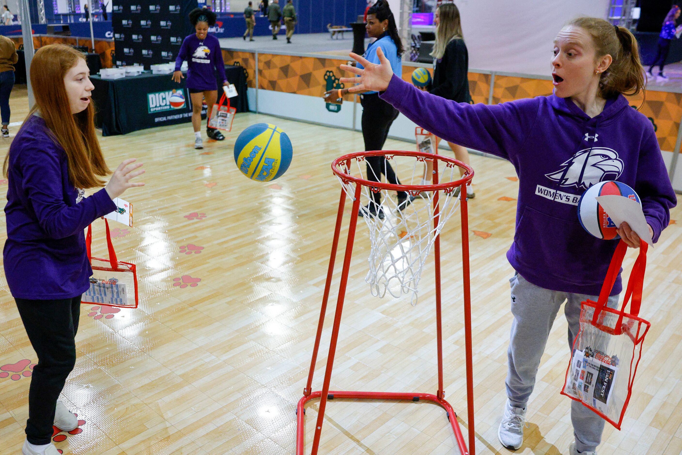 Ashland University shooting guard Sam Chable (right) blocks a shot from team manager Maddie...