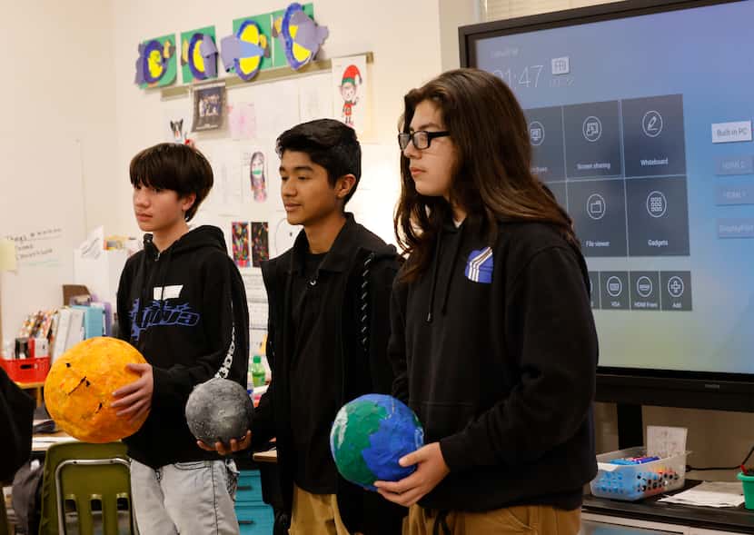 Eighth graders Ben Bright, from left, Jose Castro and Nathan Herandes explain about the...