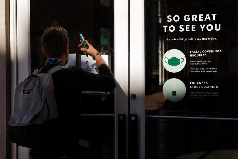 A visitor peers into the Starbucks at the West Village in Dallas, March 2, 2021. The store,...