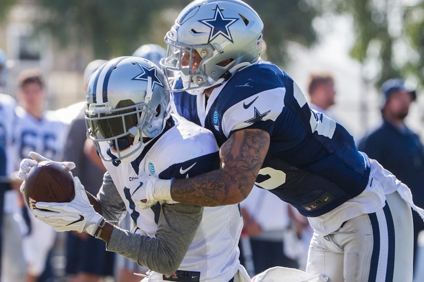 Cowboys safety Darian Thompson (right) tackles wide receiver Reggie Davis during a practice...