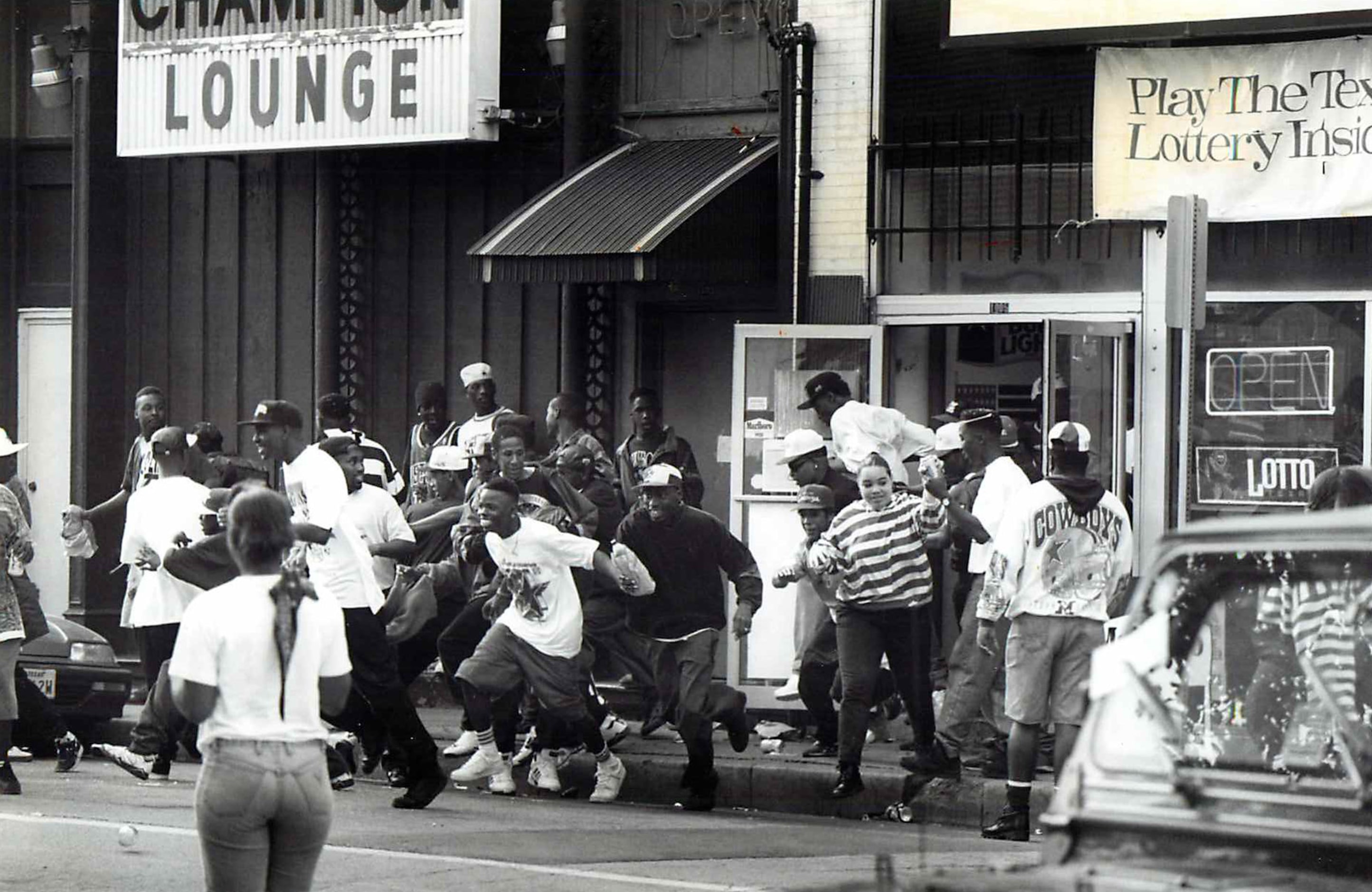 People run from the QWK Discount Liquor Store in the 1000 block of San Jacinto Street after...