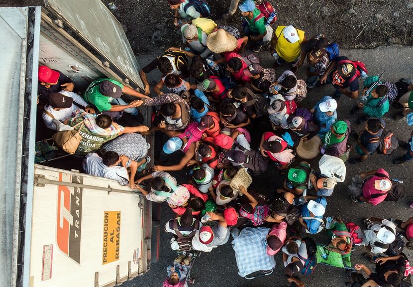 Honduran migrants taking part in a caravan heading to the U.S. get on a truck near...