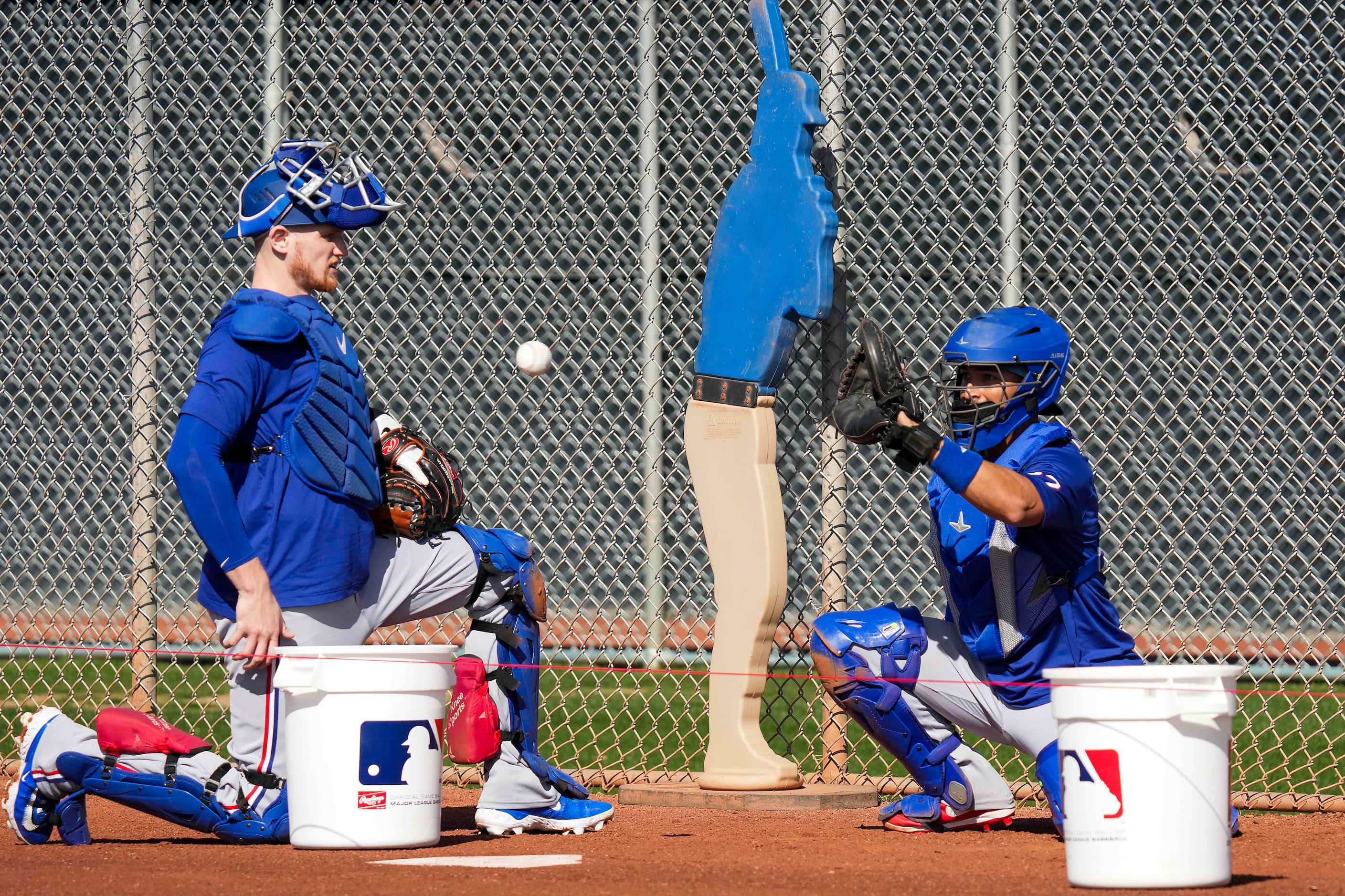 Texas Rangers catchers Sam Huff (left) and José Godoy work in the bullpen during a spring...