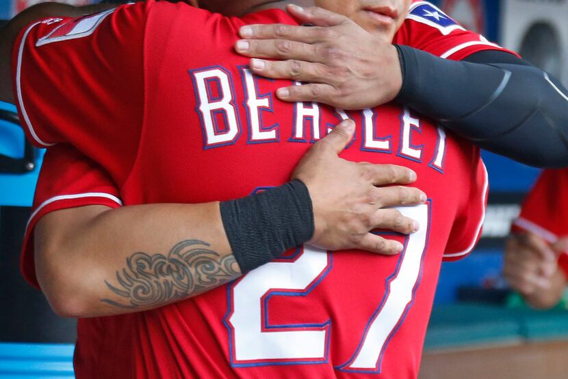 Texas Rangers right fielder Shin-Soo Choo (17) hugs third base coach Tony Beasley (27) in...