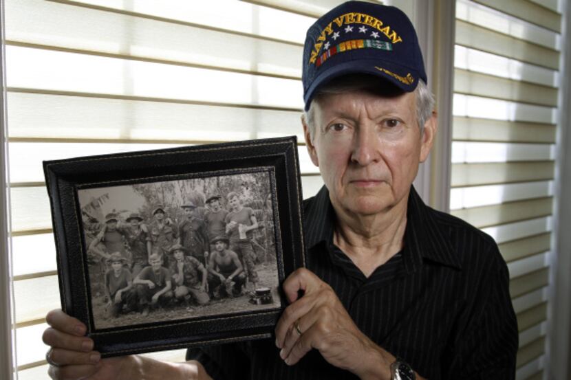 Bill Sonntag, holding a photo of his unit in Vietnam from 1970, visited the Department of...