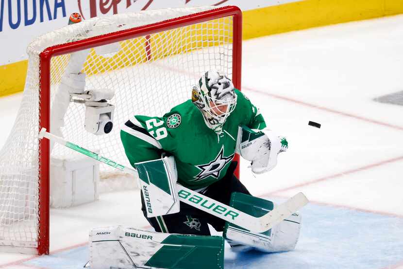 Dallas Stars goaltender Jake Oettinger (29) stops a shot by the Calgary Flames during the...