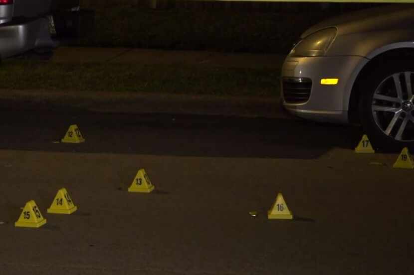 Police marked the spots where shell casings were found after a shooting that injured a...