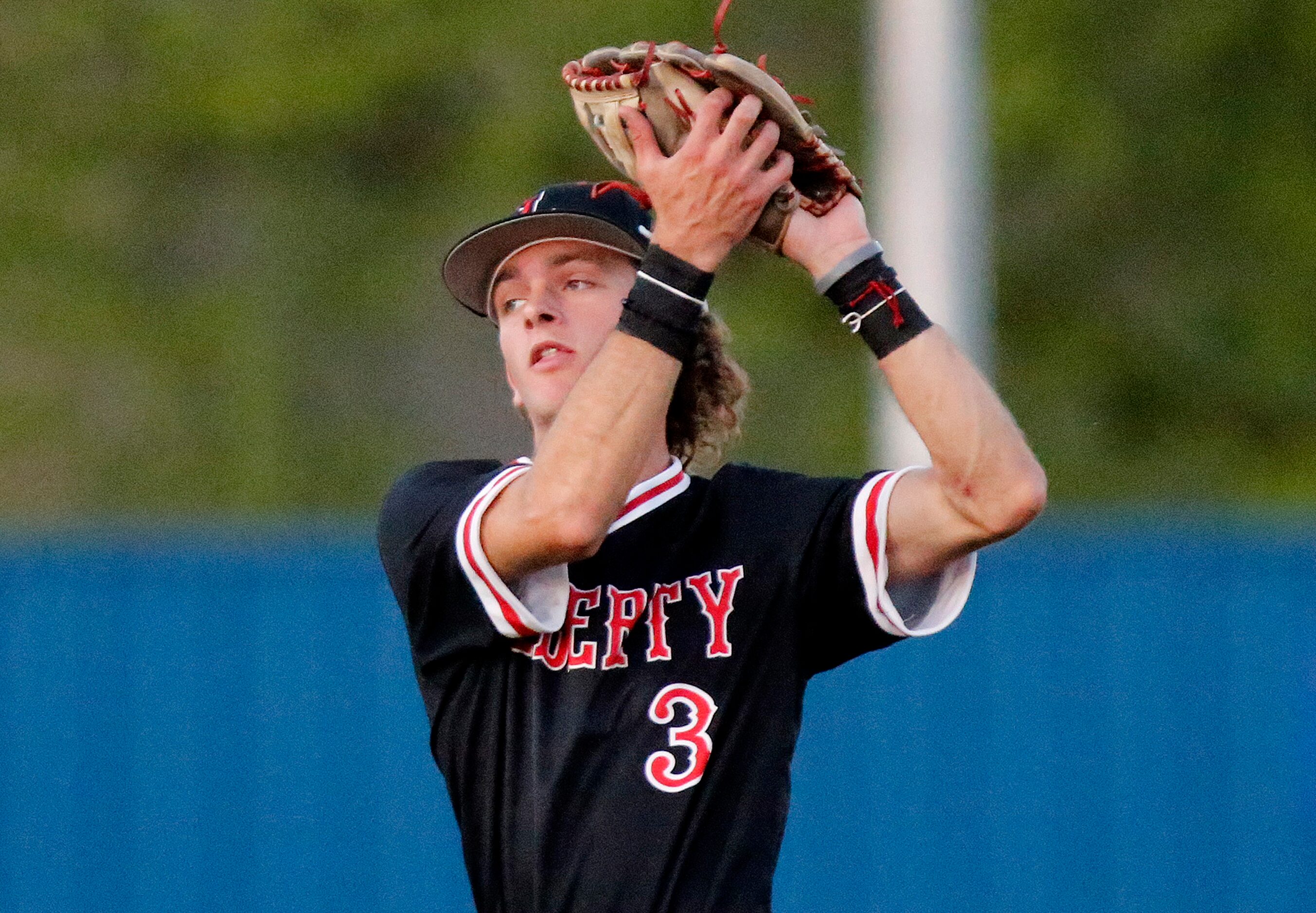 Liberty shortstop Cade McGarrh (3) makes a running catch on a fly ball to end the third...