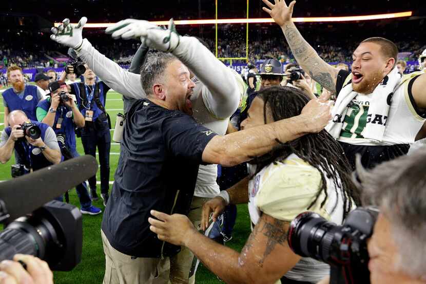 Baylor head coach Matt Rhule, center left, embraces his players as they celebrate their...