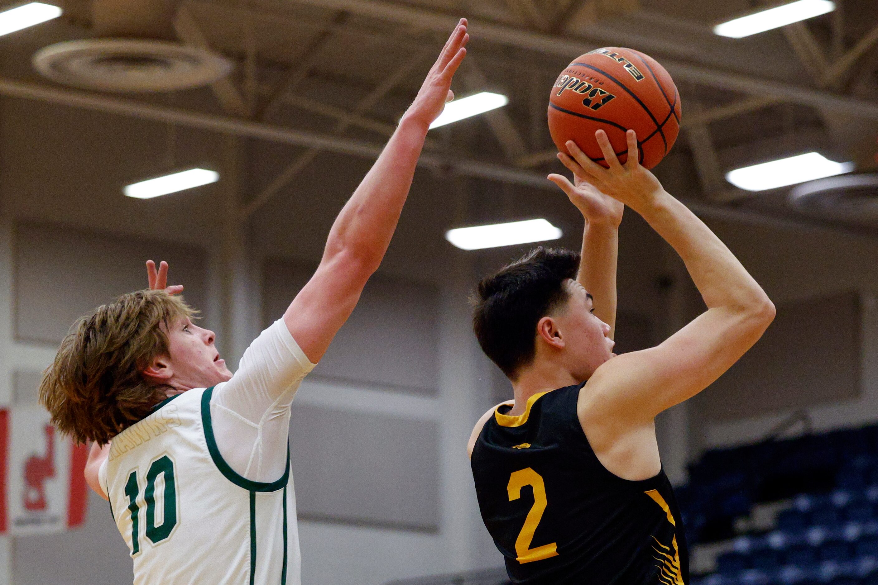 Plano East wing Narit Chotikavanic (2) shoots the ball as Birdville guard Trent Bowers (10)...