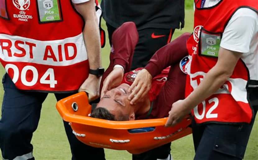 Cristiano Ronaldo sale de la cancha en camilla tras resentir una lesión de rodilla durante...