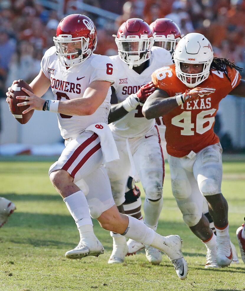 Oklahoma Sooners quarterback Baker Mayfield (6) scrambles away from pressure from Texas...