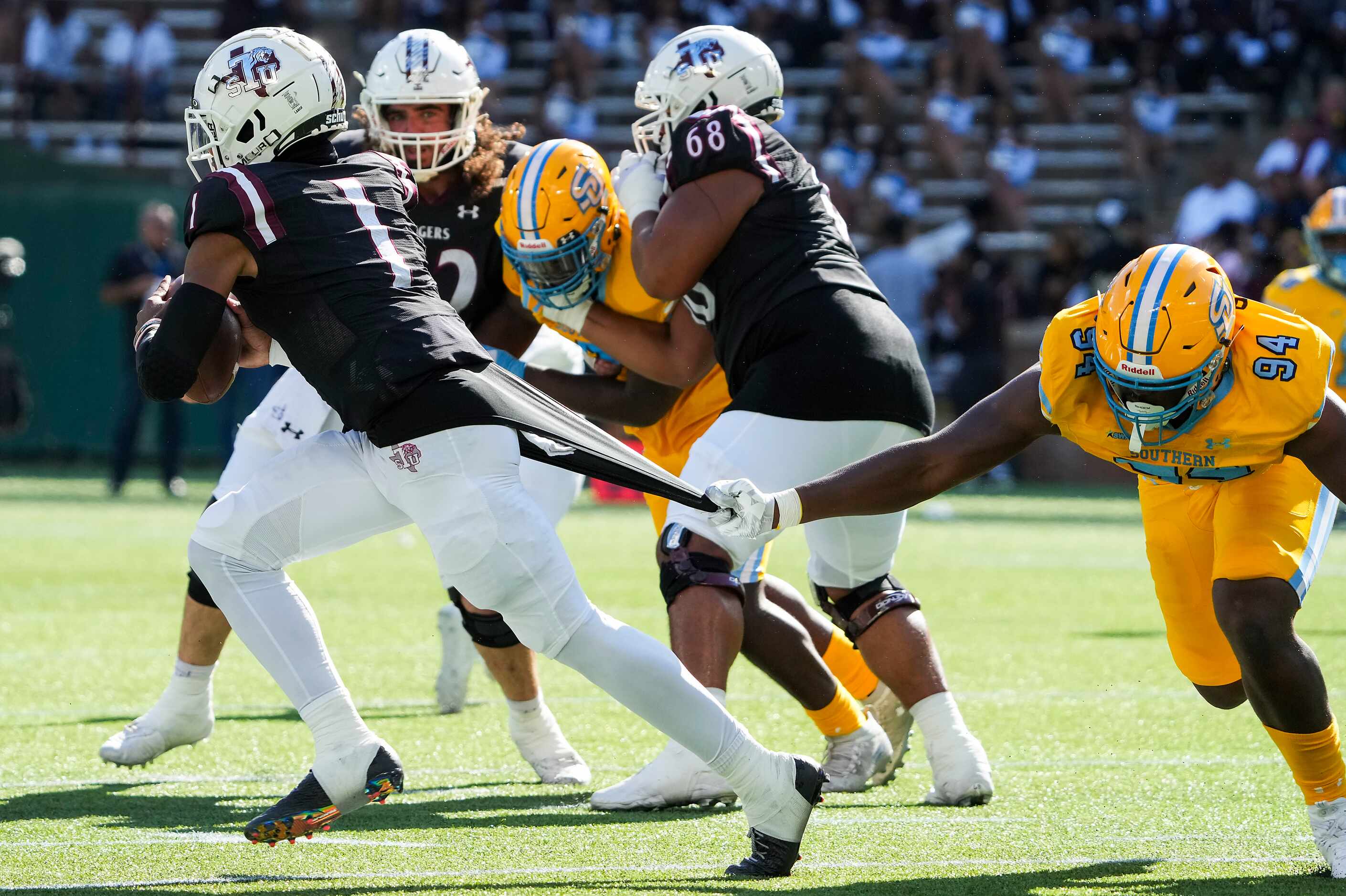 TSU quarterback Andrew Body (1) slips away from Southern  defensive lineman Camron Peterson...