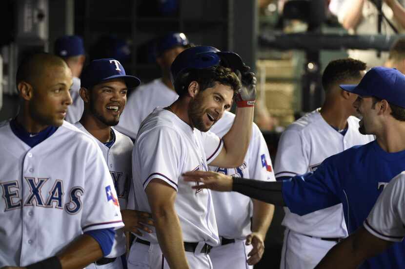 Texas Rangers first baseman Brad Snyder (64) is congratulated by teammates after he scored...
