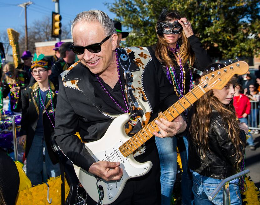 Musician and parade Grand Marshal Jimmie Vaughan plays his guitar on a float during the...