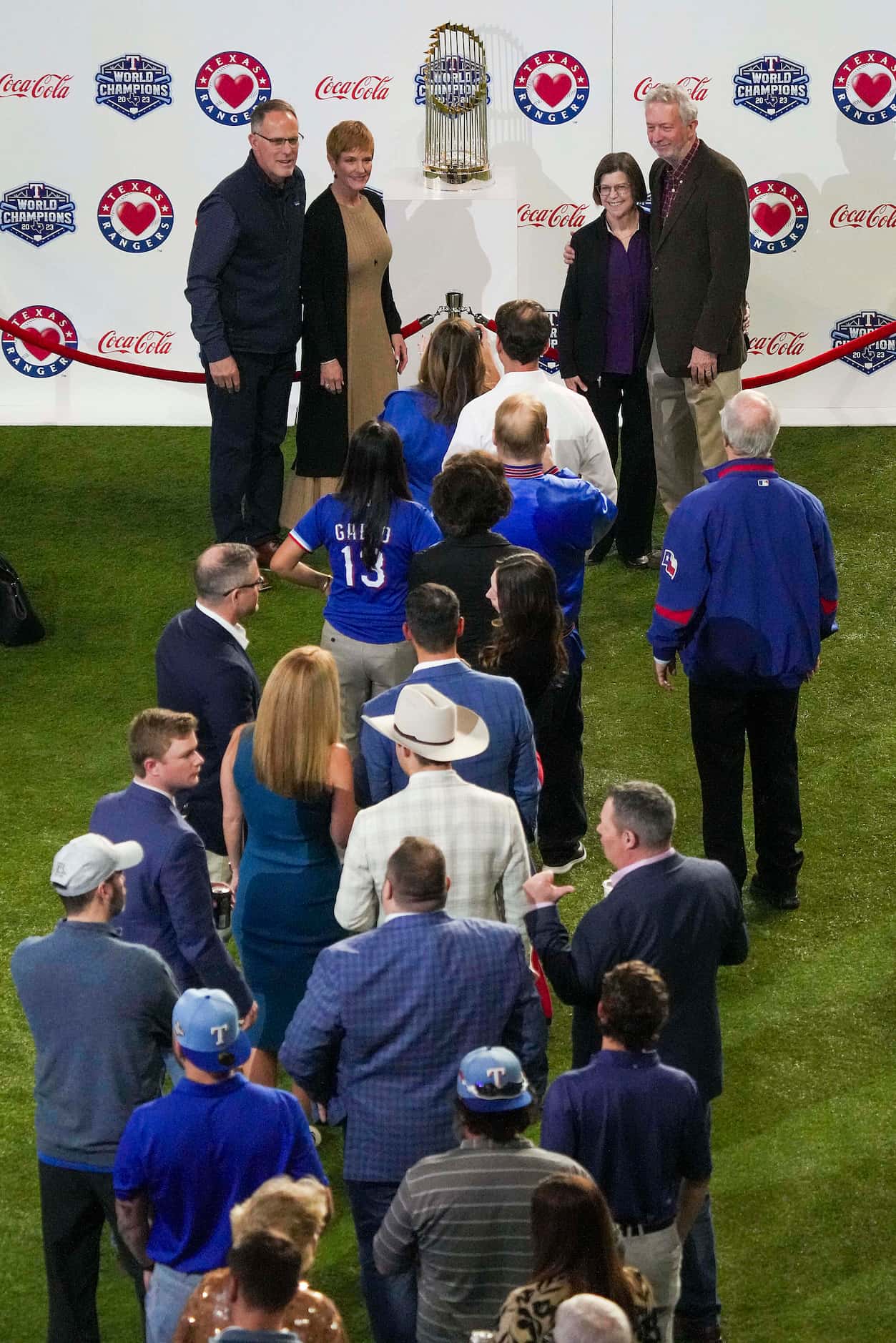 Guests wait in line to take a photo with the Commissioner’s Trophy during the Texas Rangers...