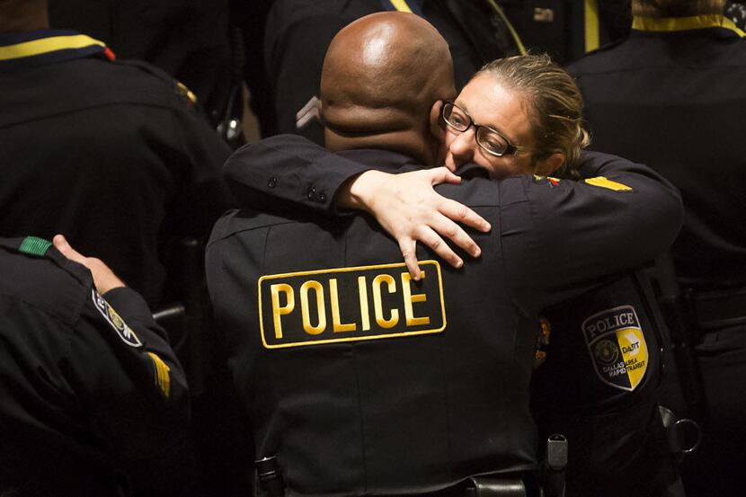 Injured Dallas Area Rapid Transit police officer Misty McBride gets a hug as she arrives for...