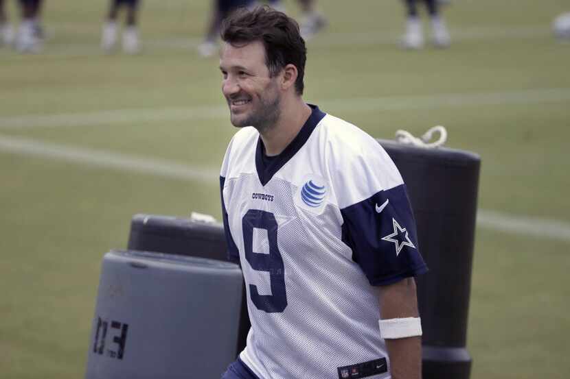 Dallas Cowboys quarterback Tony Romo smiles as he walks off the filed during an NFL football...