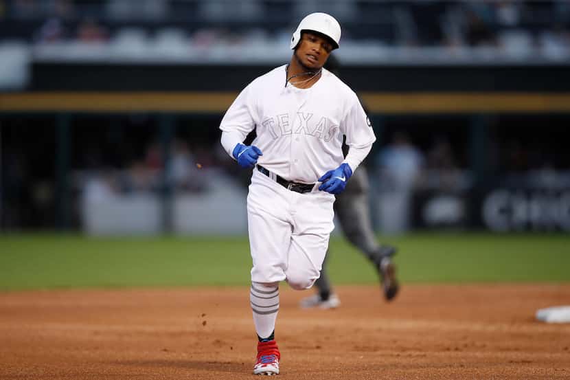 Texas Rangers' Willie Calhoun rounds the bases after hitting a three-run home run during the...