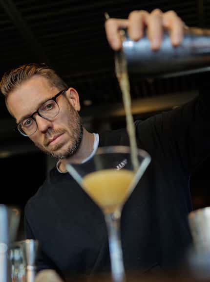 Alex Fletcher, who quit drinking alcohol two Decembers ago, pours a test cocktail into a...