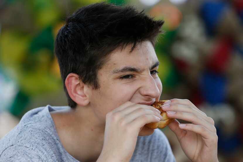 Christian Tindula, 15, of Frisco, sinks his teeth into a grilled cheese sandwich at the...