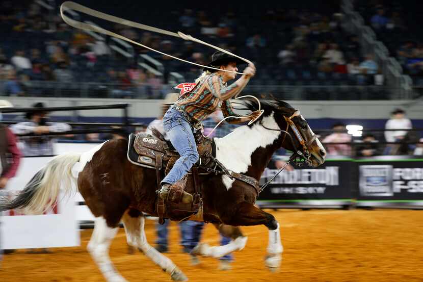 Sawyer Gilbert races from the gate before roping a calf in the breakaway roping final of the...
