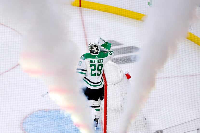 Dallas Stars goaltender Jake Oettinger (29) takes a swig of water after giving up a goal to...