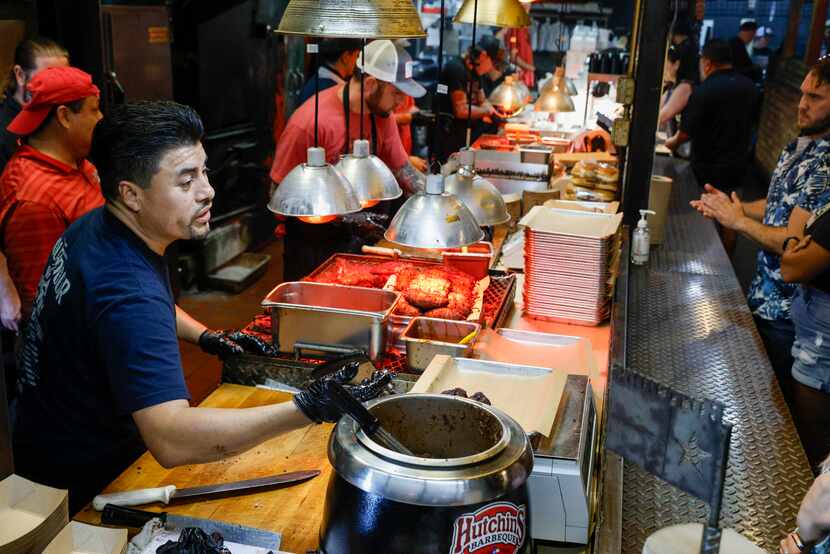 Hutchins server Joe Arriaga (left) takes an order from a customer at Hutchins BBQ, Friday,...