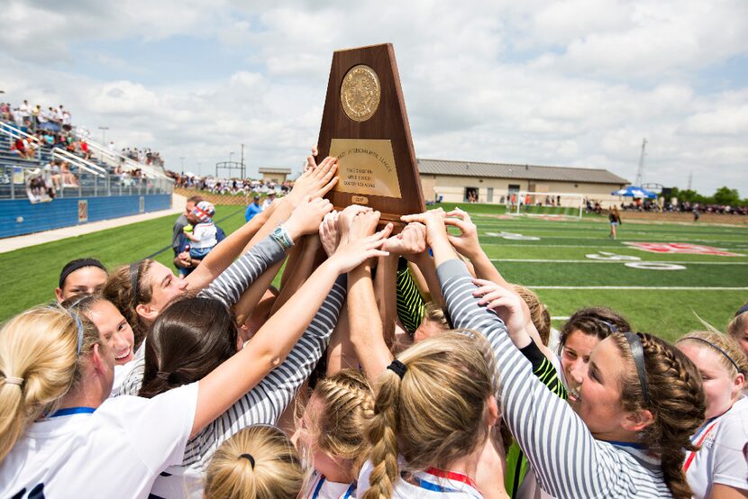 Highland Park players hoist up their state championship trophy after their win over Aledo...