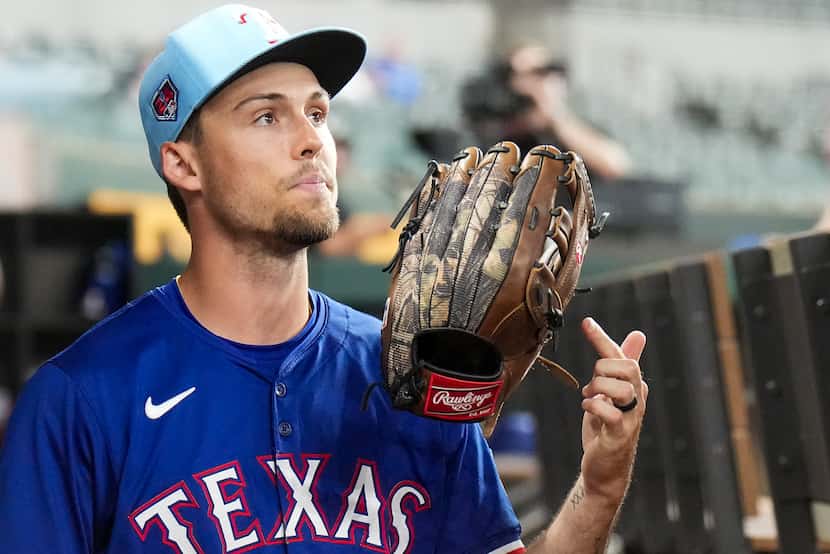 Texas Rangers outfielder Evan Carter spins his glove on his finger before an exhibition...