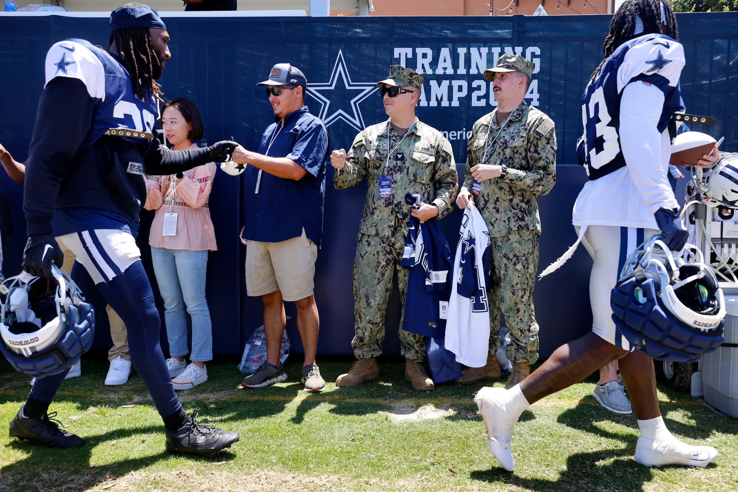 Naval Builder Third Classmen Caleb Alba (center, left) and Logan Bullock receive fist bumps...