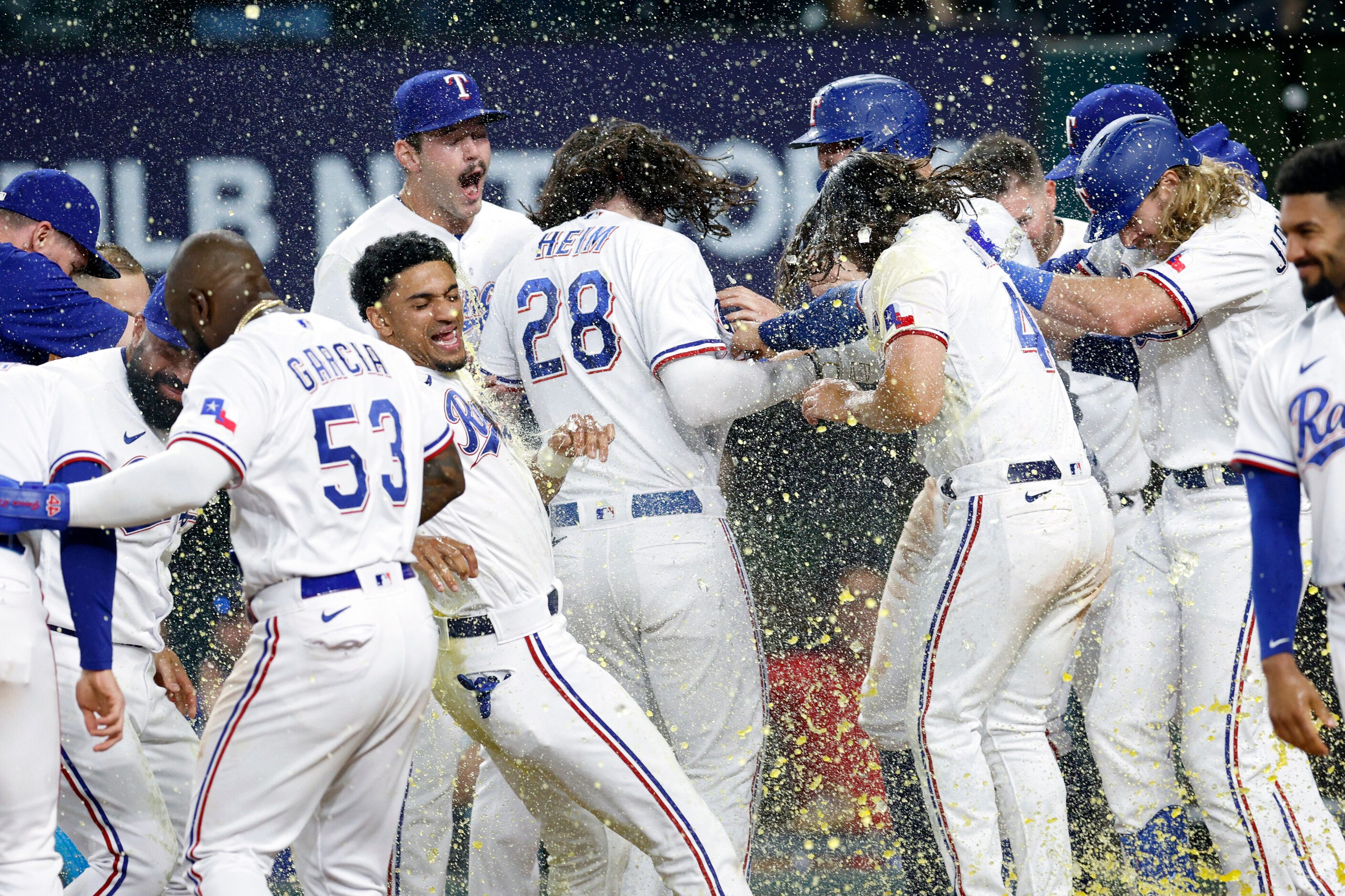 Texas Rangers players celebrate with catcher Jonah Heim (28) after hitting a three-run...