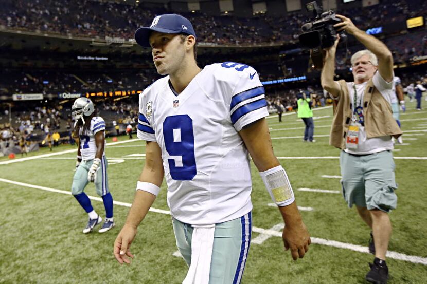 Dallas Cowboys quarterback Tony Romo walks off the field following a 49-17 loss to the New...