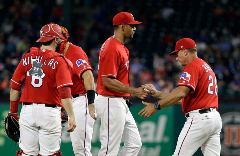 Texas Rangers catcher Brett Nicholas (6) watches as starting pitcher Tyson Ross, center,...