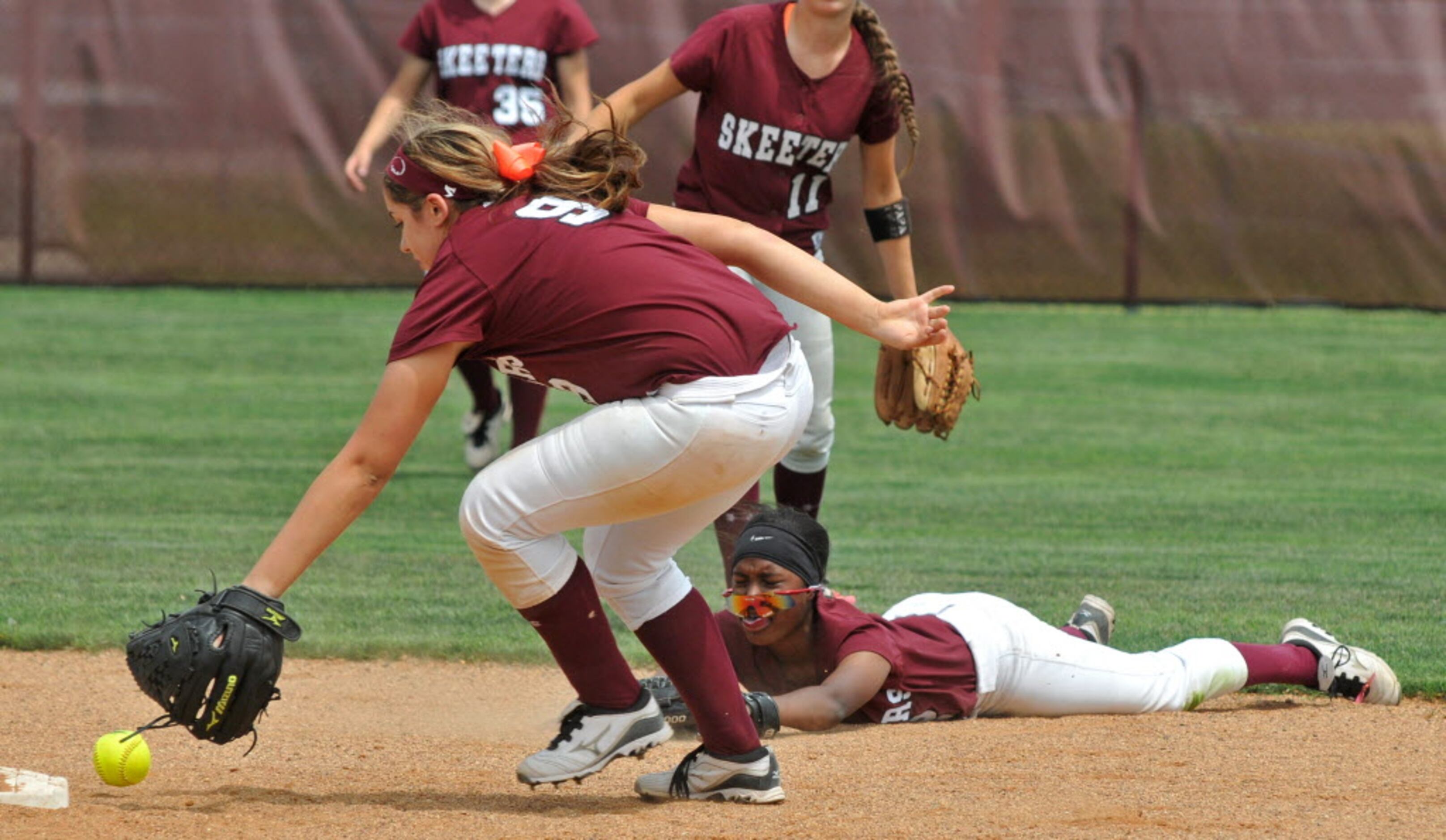 Mesquite's Lily Garza (9, foreground) fields a hit after Kailey Anderson (2, bottom right)...
