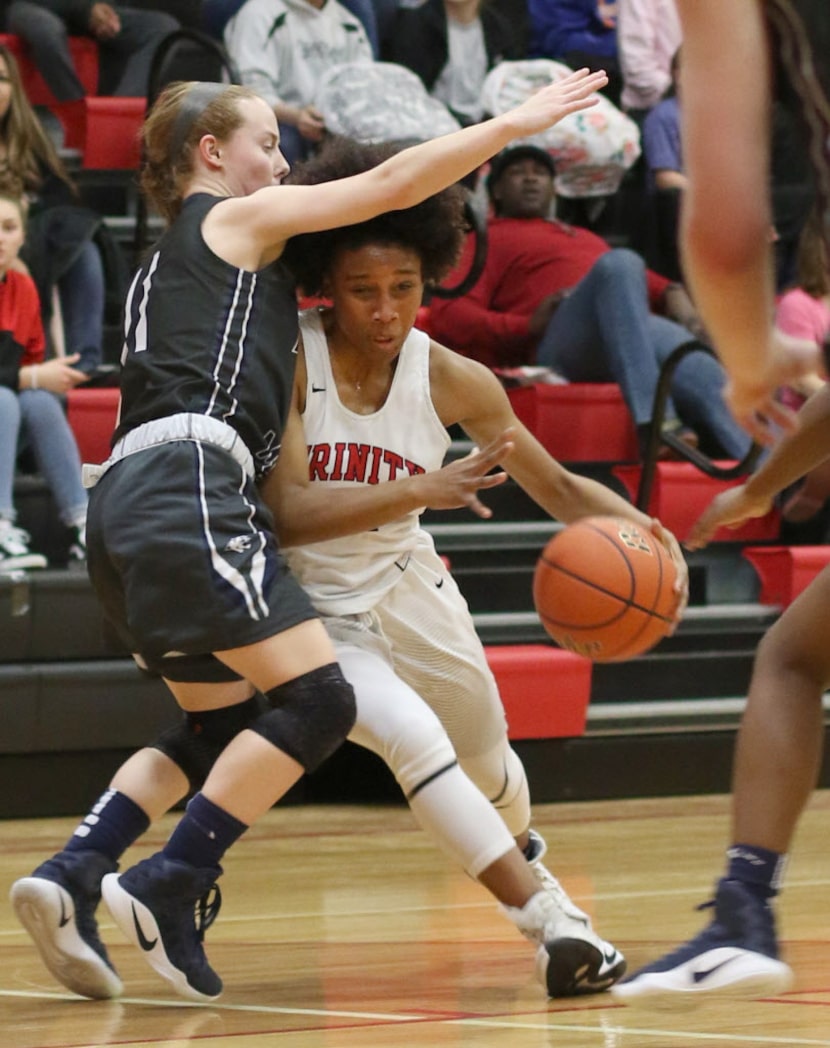 Euless Trinity guard Haleigh Talbert (21) perseveres past the defense of Flower Mound guard...