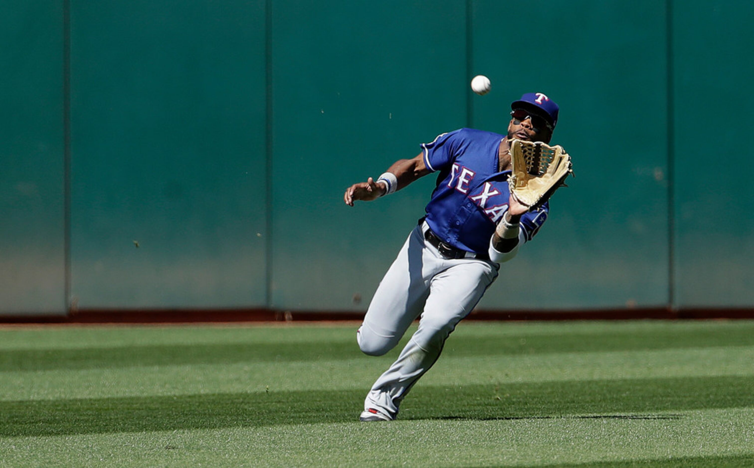 Texas Rangers center fielder Delino DeShields catches a fly ball hit by Oakland Athletics'...