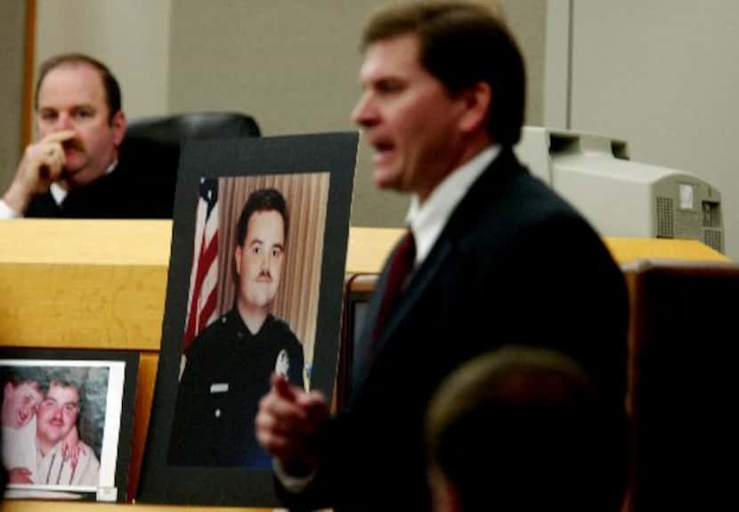 A photograph of Irving police Officer Aubrey Hawkins sits between then-state District Judge...
