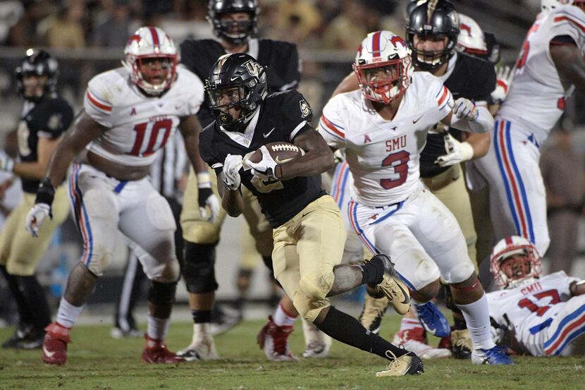Central Florida running back Otis Anderson, center, breaks free for a 30-yard rushing...